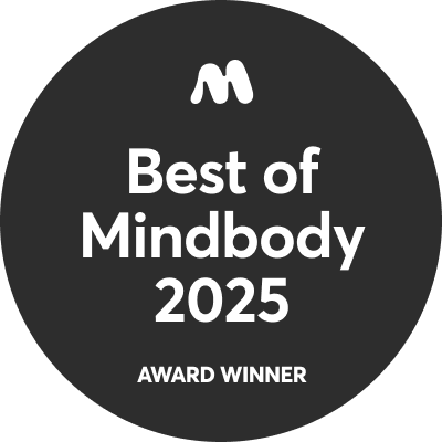 A black circular badge with a white "M" symbol at the top, white text reading "Best of Mindbody 2025," and "AWARD WINNER" at the bottom.